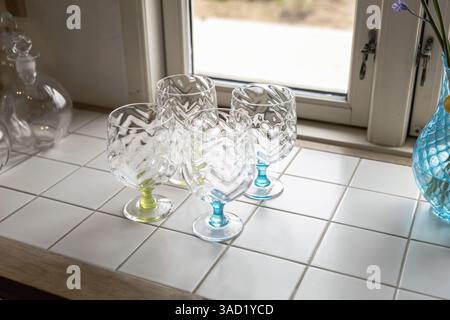 Stylish handmade empty fine wine glasses on the table by the window. High quality photo Stock Photo