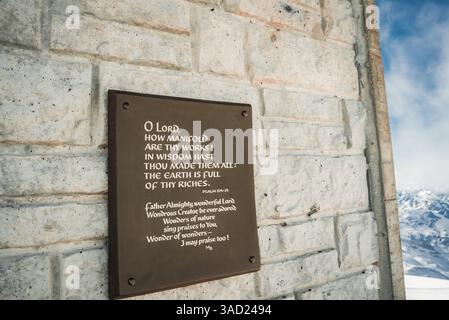 Plaque with Psalm 104 24 on Stone Wall in Snowy Alpine Setting Stock Photo