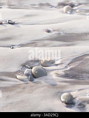 Round pebbles in the beach sand, view from above Stock Photo