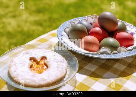 Easter cookie with colorful Easter eggs on a table in the garden Stock Photo