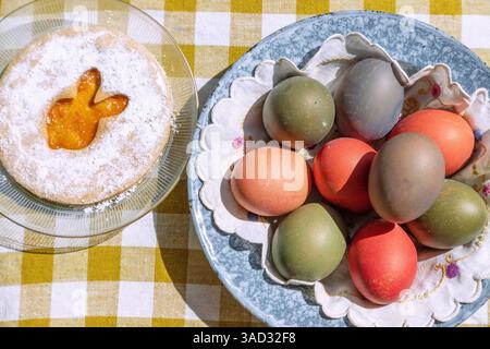 Easter cookie with Easter bunny motif with colorful Easter eggs on table with checkered tablecloth Stock Photo