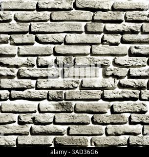 Gray brick wall creating a textured background with visible light and shadow effects.Belarus Stock Photo