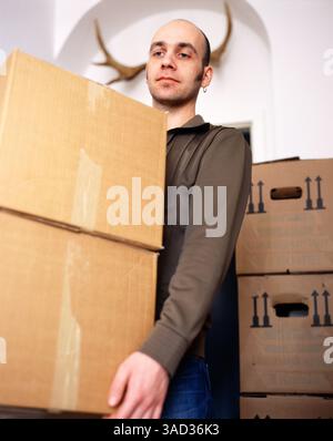 Young Man Carrying Cardboard Boxes Stock Photo