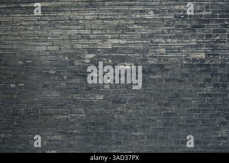 Full frame shot of a weathered dark gray brick wall creating a rustic and textured background.Belarus Stock Photo