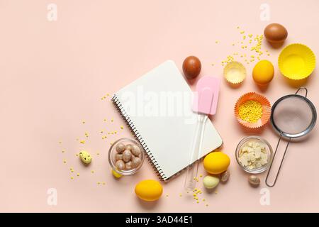 Blank notepad for recipes with Easter eggs and kitchen tools on beige background Stock Photo