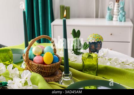 Festive table serving with painted eggs, flowers and cake for Easter celebration, closeup Stock Photo
