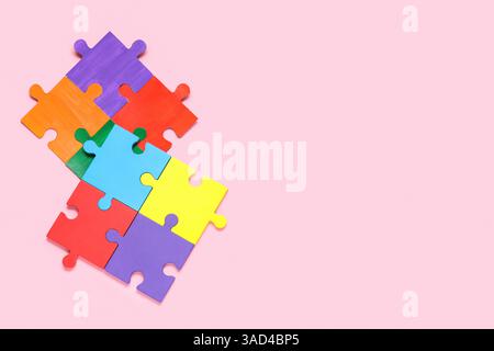 Different colorful puzzle pieces on pink background. Autistic disorder concept Stock Photo