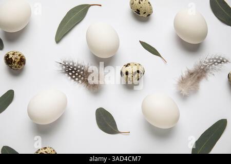 Chicken and quail eggs with leaves on grey background. Easter celebration Stock Photo