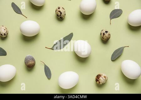 Chicken and quail eggs with leaves on green background. Easter celebration Stock Photo