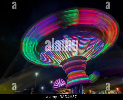Colorful motion blur of spinning ride at a carnival. Stock Photo