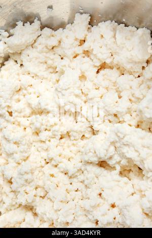 Cottage cheese top view. Homemade cheese curd texture. DIY cottage cheese recipe with milk and lemon. High in protein and calcium. Selective focus. Stock Photo