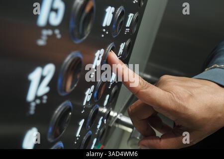 Close-up of a hand pressing elevator button on the floor panel Stock Photo