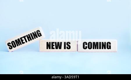 The message is something new, written on wooden blocks on a light background. The conceptual symbol is "Something new is coming." A place to copy. Stock Photo