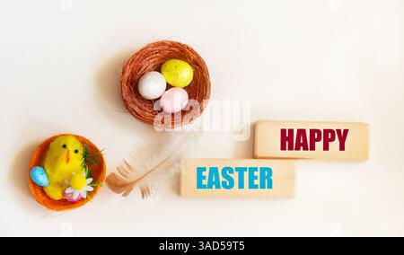 A bright Easter spring composition. Easter inscription on wooden blocks on a light background. Colorfully decorated eggs Stock Photo