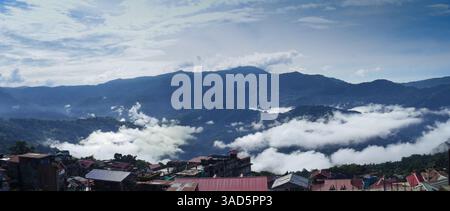 Panoramic View of Mountainous Landscape with Clouds Above a Residential Village Stock Photo