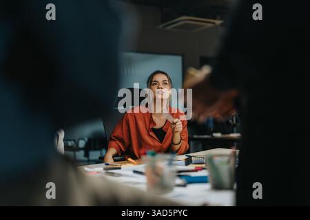 Focused business team collaborating on project ideas late at night Stock Photo