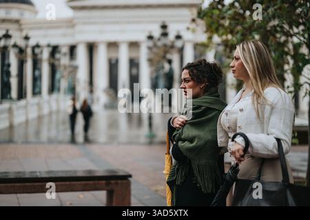 Two women strolling through a city square on a moody rainy day Stock Photo