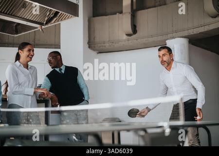 Multicultural business workers enjoying a break playing table tennis Stock Photo