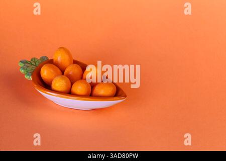 Gourmet festive imagery featuring chocolate eggs carefully arranged in a carrot plate on a warm-toned background Stock Photo