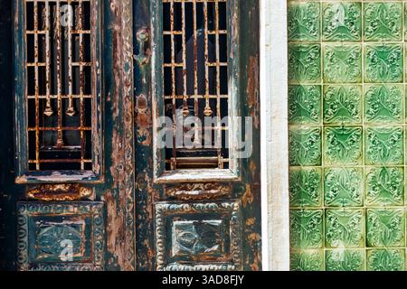 Weathered green painted wooden door with green Portuguese tiles, lagos, Portugal Stock Photo