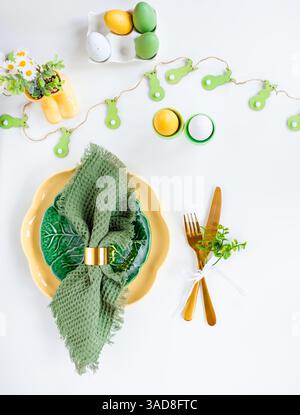Happy Easter. Easter celebration concept. Top view vertical Napkin empty green and yellow plate, Easter eggs, on isolated white background. Copy space Stock Photo