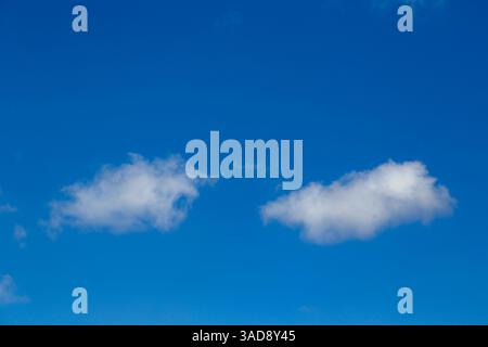 Small fluffy white clouds in s blue summer sky for use as a background texture Stock Photo