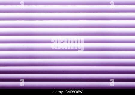 Horizontal slats of an interior mini-blind showing the rows of transitioning shadows in shades of purple Stock Photo
