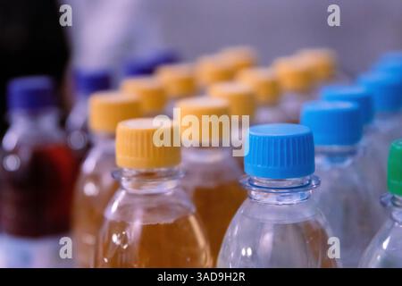 Many blue, yellow, green drinking water and refreshment beverage bottle caps and pure drinking water bottles in a drinking water production plant or s Stock Photo