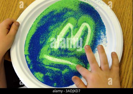 Jun 10, 2008 - Lilburn, Georgia, USA - First grade student practices writing the letter 'm' in colored sand as a means of learning to print his name at private Providence Christian Academy in Lilburn (Credit Image: Robin Nelson/ZUMAPRESS.com) Stock Photo