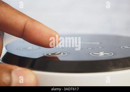 Adjusting settings on a modern device at home during the day Stock Photo