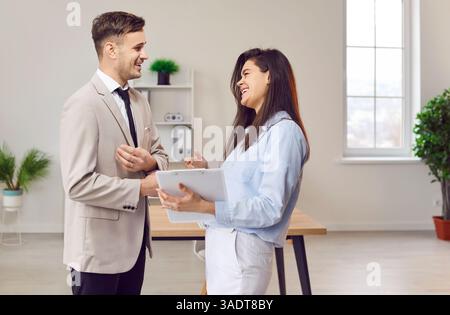 Office happy engaged diverse managers in formal clothed discussing business project, talking Stock Photo