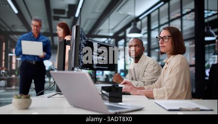 Young African American Woman Coding Software On Computer In Office. Diverse Group Stock Photo