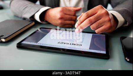 Focused African American Executive Reviews Insurance Contract On Office Computer Stock Photo