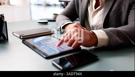 Young African American man analyzing data on computer spreadsheet software. Stock Photo