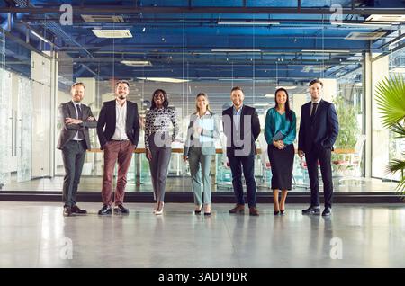 Team of successful company employees or executives standing together and smiling. Stock Photo