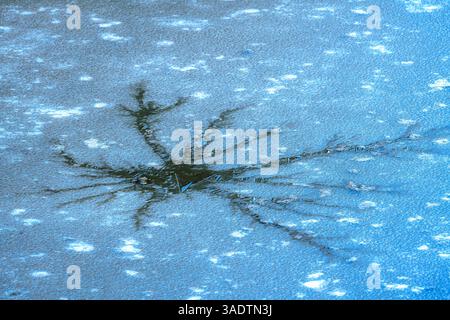 Abstract image of a crack in the ice cover of a muddy lake Stock Photo