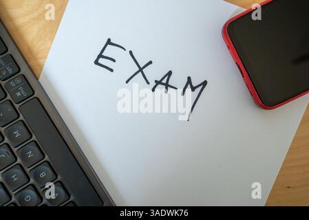 word exam written with black pen on paper - a reminder of school collage or work assessment Stock Photo