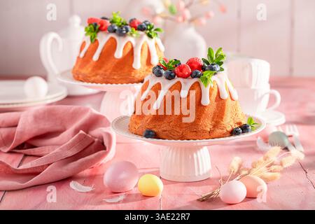 Delicious Easter ring cake on holiday table with decorations. Cake, Easter eggs and flowers for Easter. Stock Photo