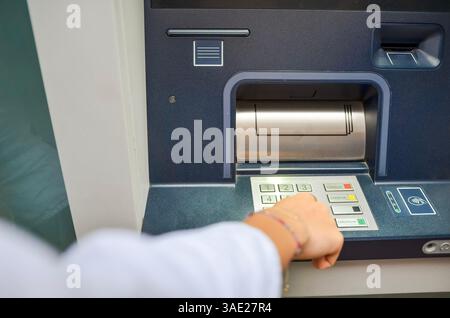 Woman using atm, entering pin code on keypad, withdrawing money from bank account, modern banking technology Stock Photo