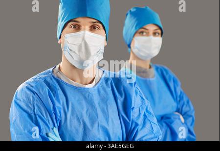 Isolated shot of woman and man medic workers, wearing blue uniform, standing self confident Stock Photo