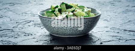 Smashed cucumber salad panorama, healthy vegan food, green snack, shot on a black background Stock Photo