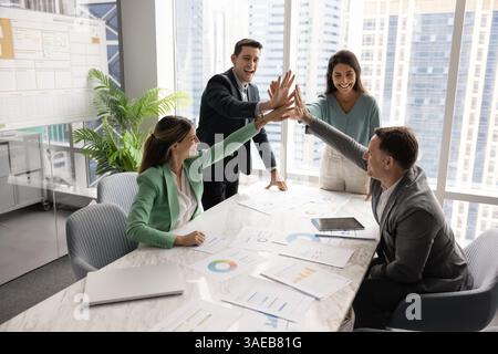Excited positive team of managers celebrating business success Stock Photo