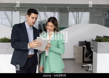 Busy office colleagues using tablet together, working on business plan Stock Photo
