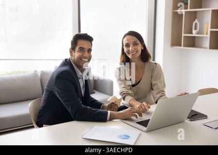 Business professionals, man and woman sitting at table in office Stock Photo