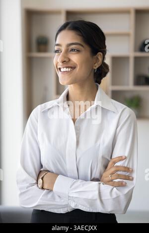 Dreamy successful Indian businesslady smiling looking into distance Stock Photo