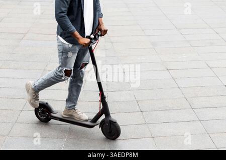 Unrecognizable guy having pleasant ride on electric kick scooter Stock Photo