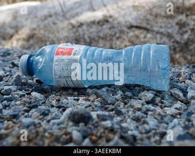 Empty plastic water bottle laying on the ground Stock Photo