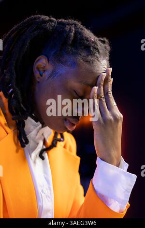 Fatigued teleworker suffering from painful headache, feeling overworked, closing eyes after working too much on job tasks. Exhausted young woman hurting from migraine while working from home Stock Photo