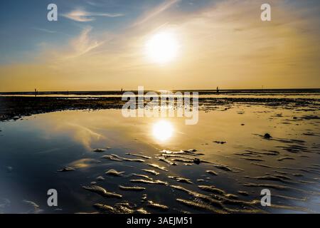Sunset with clear reflection in the calm water on a sandy beach, North Sea beach 27476 Cuxhaven/Sahlenburg-Germany Stock Photo