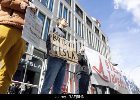 Berlin, Germany - 5 April 2025: People demonstrate against Tesla owner Elon Musk in front of a Tesla shop in Berlin during an international day of act Stock Photo